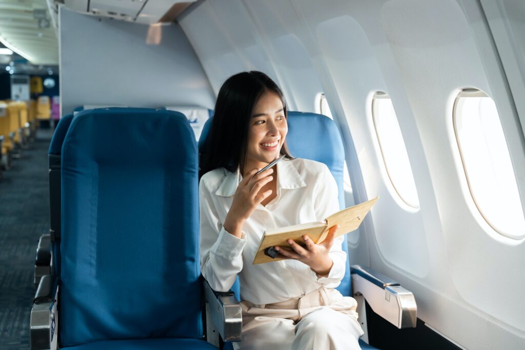asian female thinking about work in airplane concept business traveling and technology concept